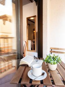 una mesa con un libro y una taza de café y un libro en Hotel Eden Mar, en Guardamar del Segura