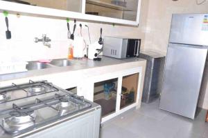 La cuisine est équipée d'une cuisinière, d'un évier et d'un réfrigérateur. dans l'établissement Jumeirah on the hills, Mamelles, à Dakar