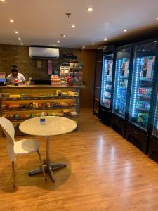 a restaurant with a table and a counter with refrigerators at FLAT 1417 in Águas Claras