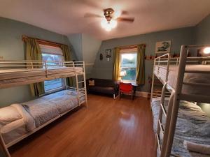 a room with two bunk beds and a couch at HI Charlottetown Backpacker's Inn in Charlottetown