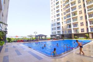 Ein Mann und ein Kind spielen im Pool in der Unterkunft Smile Apartment in Hạ Long