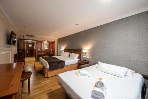 um quarto de hotel com duas camas e uma mesa em Eurostars Araguaney em Santiago de Compostela