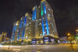 duży budynek z niebieskimi światłami w nocy w obiekcie Smile Apartment w Ha Long