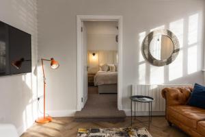 a living room with a couch and a mirror at The Weights and Measures Office in Berwick-Upon-Tweed