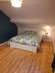 a small bed in a room with a wooden floor at Maison "Chez Barbara" 6-8personnes in Lalizolle