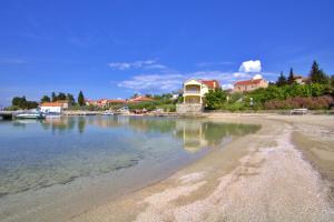 a house on the shore of a body of water at Sandy Beach Studio in Lukoran
