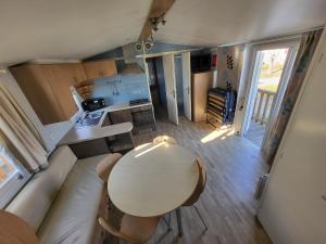 a small living room with a table and a kitchen at Campeggio Don Bosco in Lido di Jesolo