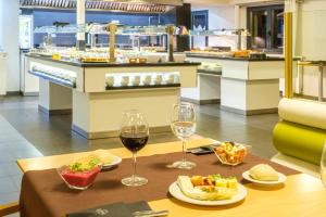a table with two glasses of wine and food at Hotel Cristina in Pas de la Casa