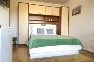 a bedroom with a white bed with a green blanket at Sandy Beach Studio in Lukoran +23 photos