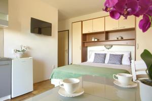 a bedroom with a bed and two cups on a table at Sandy Beach Studio in Lukoran