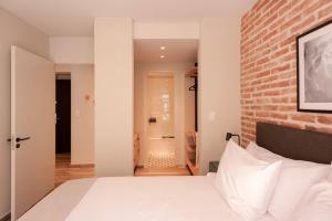 Un dormitorio con una pared de ladrillo y una cama en Cozy & Modern Luxe Apartment -La Galerie San Telmo- 228 en Buenos Aires