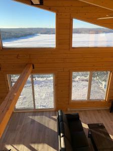 Cabaña de madera con sala de estar con ventanas grandes. en Chalets domaine Otis, en Saint-Félix-d'Otis