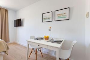 a white dining room with a white table and chairs at NEW Suite reformada con excelente ubicación in Seville