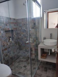 a bathroom with a glass shower and a sink at Casa las Galias. in Tlalixtac de Cabrera