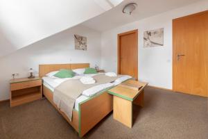 - une chambre avec un grand lit et des oreillers verts dans l'établissement Apartments Tabor, à Naklo