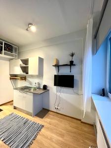 eine Küche mit weißen Schränken und einem Waschbecken im Zimmer in der Unterkunft Savi Apartment 3 in Pärnu