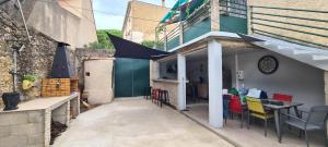 Un patio con mesa y sillas y un edificio. en Chez mamie, en Bassan
