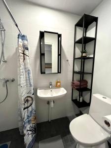 y baño con lavabo, aseo y espejo. en Savi Apartment 3 en Pärnu