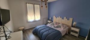 Un dormitorio con una cama y un televisor de pantalla plana. en Chez mamie, en Bassan 4 fotos más