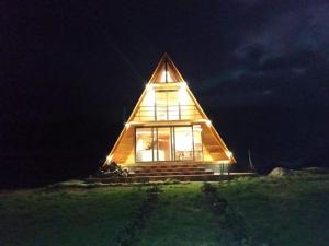 Cabaña de madera con techo triangular por la noche en Hacienda El Rejo, en Machachi