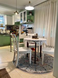 a kitchen with a table with white chairs and a table and chairsktop at Evangeline House in Da Lat
