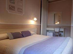 a bedroom with a large bed and a desk at Hotel Ristorante Moderno in SantʼAntìoco