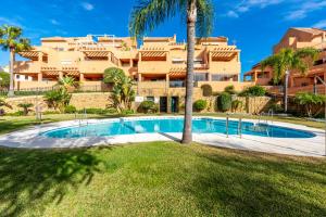 a swimming pool in front of a building at Los Lagos Golf II Charming 3 bedroom apartment in Marbella in Marbella