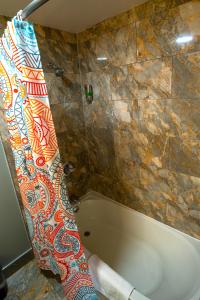 Philly Inn & Suites في فيلادلفيا: حوض استحمام في حمام مع جدار من البلاط