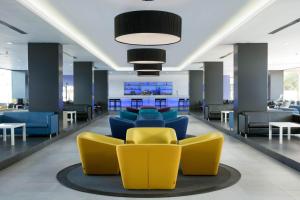 a lobby with yellow and blue chairs and tables at Hotel Gran Canaria Princess - Adults Only in Playa del Ingles