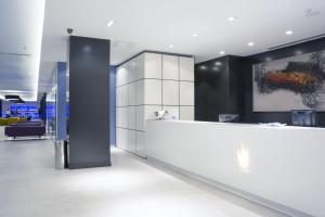 an office lobby with a reception counter and a painting at Hotel Gran Canaria Princess - Adults Only in Playa del Ingles