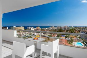a balcony with a table and chairs and a view of the city at Hotel Gran Canaria Princess - Adults Only in Playa del Ingles