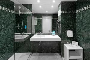 a black and white bathroom with a sink and a mirror at Hotel Gran Canaria Princess - Adults Only in Playa del Ingles
