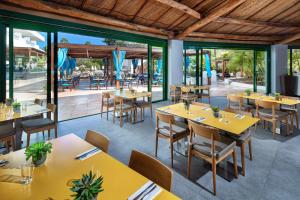 an empty restaurant with yellow tables and chairs at Hotel Gran Canaria Princess - Adults Only in Playa del Ingles