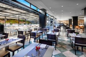 a restaurant with tables and chairs and a large window at Hotel Gran Canaria Princess - Adults Only in Playa del Ingles