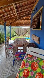 a patio with a wooden table and chairs and a table and bench at Aconchego da Roça in Gonçalves