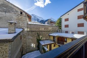 a balcony with snow on the roofs of buildings at Appartamento Claire in Courmayeur