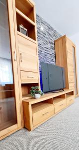 a wooden entertainment center with a television in it at Larisa Apartment in Cluj-Napoca