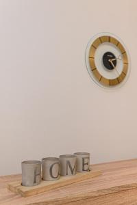 un reloj y tres tazas en un estante de madera con la palabra mamá en Luxury Studios - Soarelui 10, en Brasov