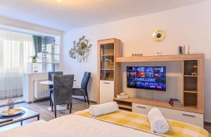 Un dormitorio con una cama y un televisor en una habitación. en Luxury Studios - Soarelui 10, en Brasov 37 fotos más
