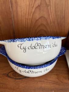 a blue and white bowl sitting on a wooden table at TY DOLMEN DU Plages à pied 2 vélos WIFI in Carnac