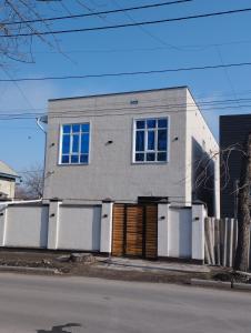 a gray house with a wooden door in front of a street at Pravda in Bishkek