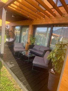 a porch with couches and a table and a glass table at Chalet Sijkovsky in Stará Lesná