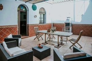 a patio with a table and chairs in a room at Casa rural con jacuzzi, sauna, barbacoa y barra in Cabeza la Vaca