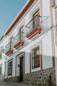 - un bâtiment blanc avec 2 balcons et une porte dans l'établissement Casa rural con jacuzzi, sauna, barbacoa y barra, à Cabeza la Vaca