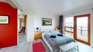 sypialnia z dużym łóżkiem i czerwoną ścianą w obiekcie Brenna: Cliffside Apartment w mieście Hellissandur