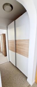Cette chambre est dotée d'un mur blanc avec une porte coulissante. dans l'établissement Larisa Apartment, à Cluj-Napoca
