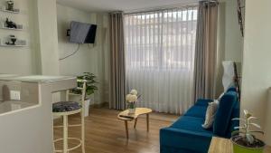 a living room with a blue couch and a window at Confortable APT-Estudio con WIFI,Neflix y PKG Gratis in Lima