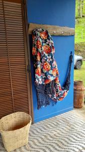 a blanket hanging on a blue wall next to a basket at Aconchego da Roça in Gonçalves