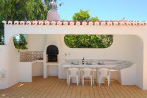 a patio with a table and chairs and a fireplace at Vivenda Cinquenta e Sete in Poço Partido