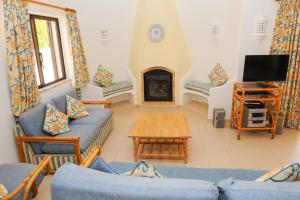 a living room with blue couches and a fireplace at Vivenda Cinquenta e Sete in Poço Partido